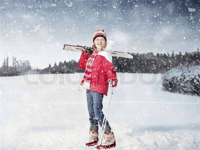 Girl carrying cross country skis in snow, stock photo