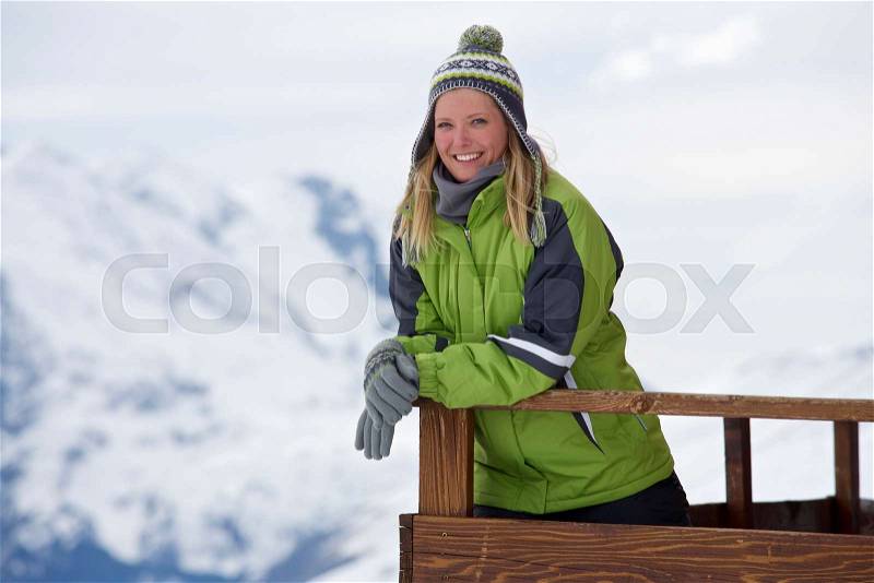 Woman relaxing on ski lodge balcony, stock photo