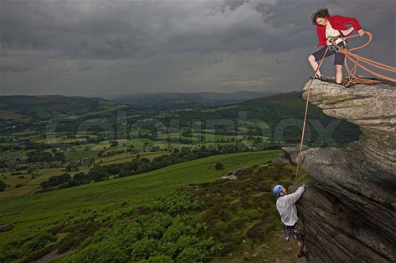Rock climbers scaling steep rock face, stock photo