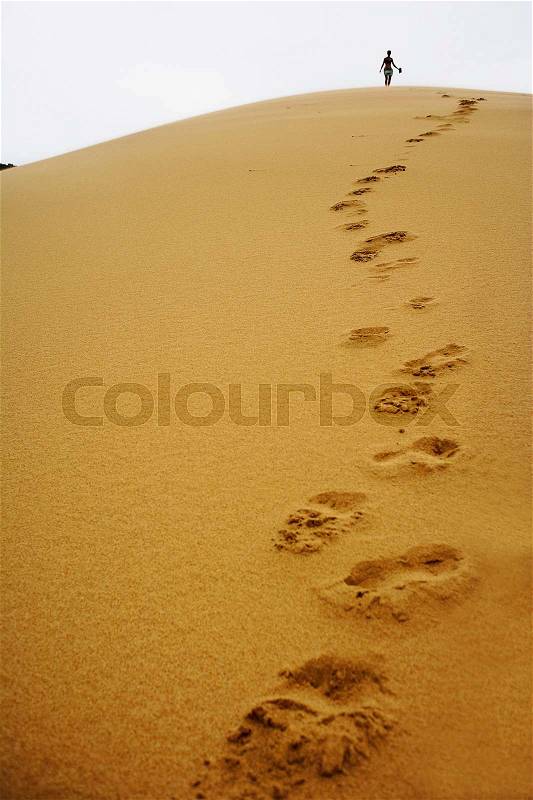 Footsteps in sand dune, stock photo
