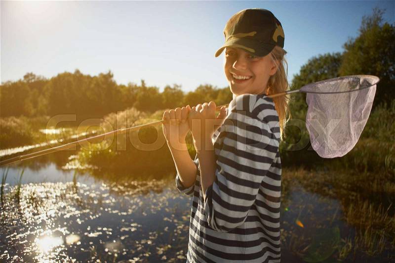 Young Woman by pond with fishing net, stock photo