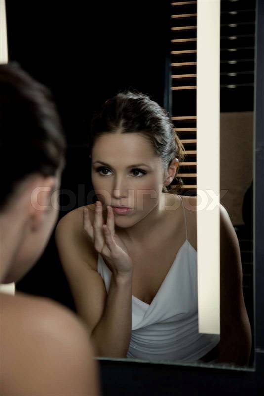 Woman in front of mirror, stock photo