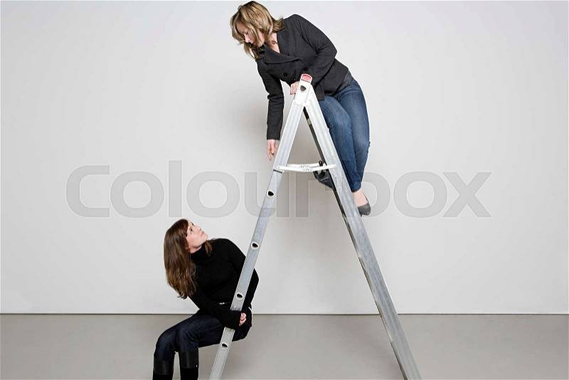Two women on step ladder, stock photo