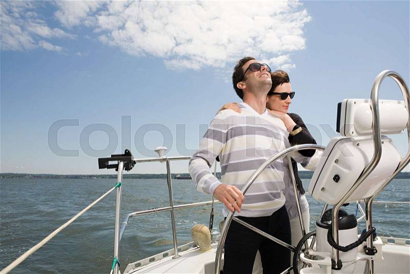 Couple sailing a yacht, stock photo