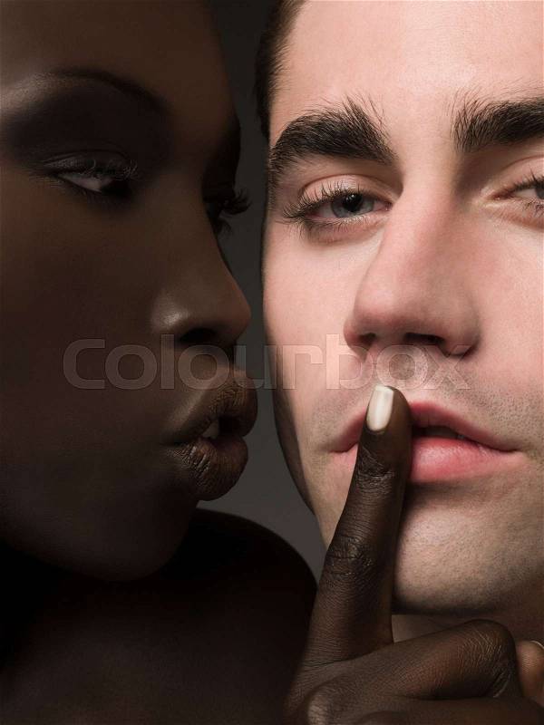 Woman with finger on mans lips, stock photo