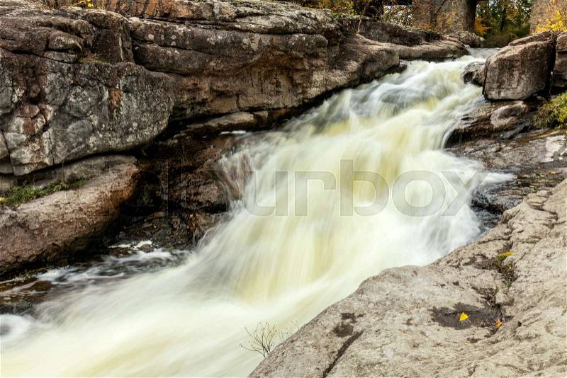 Powerful mountain river close up. Crystal water flows through mossy boulders and rocks. Dark vintage toning filter. Buky Canyon on the Hirs`kyi Tikych river in Ukraine, stock photo