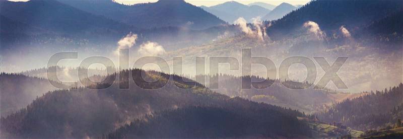 Spring mountain panorama. Foggy forest on hills in the morning, stock photo