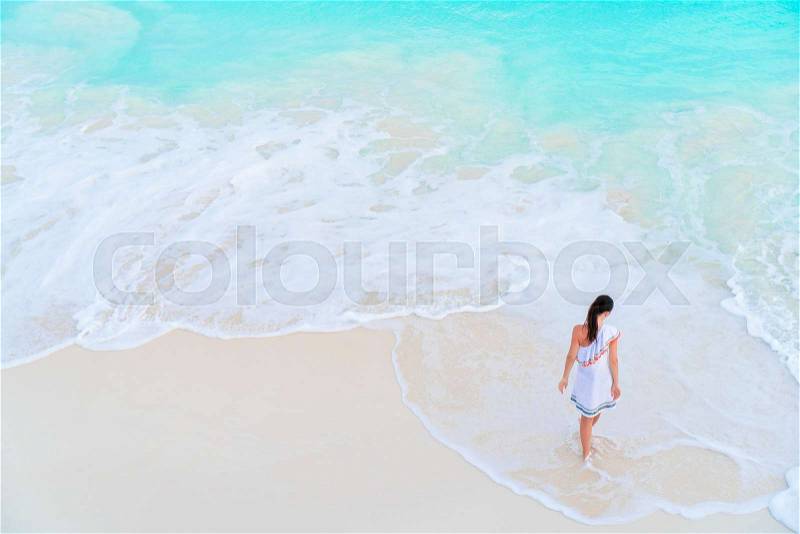 Adorable active girl at beach during summer vacation, stock photo