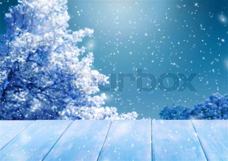 Christmas background with trees in the snow, wooden table and snowfall. New Year winter holidays theme. Empty space for your decoration, text or advertising, stock photo