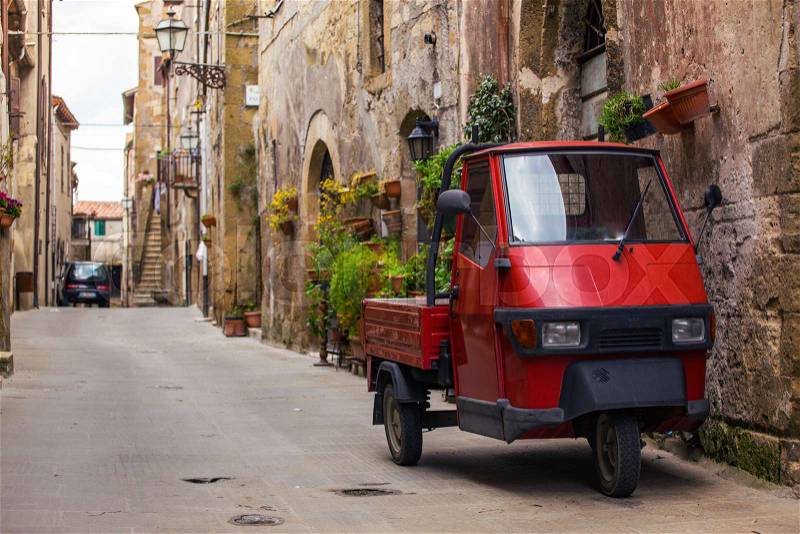 Piaggio Ape standing at the empty street of old italian town , stock photo