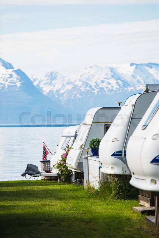Camping site with the blurred camper caravan cars on a fjord shore , stock photo
