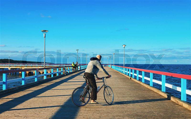 Man riding a bicycle on the Sea Bridge in Palanga, Baltic Sea resort, Lithuania, stock photo