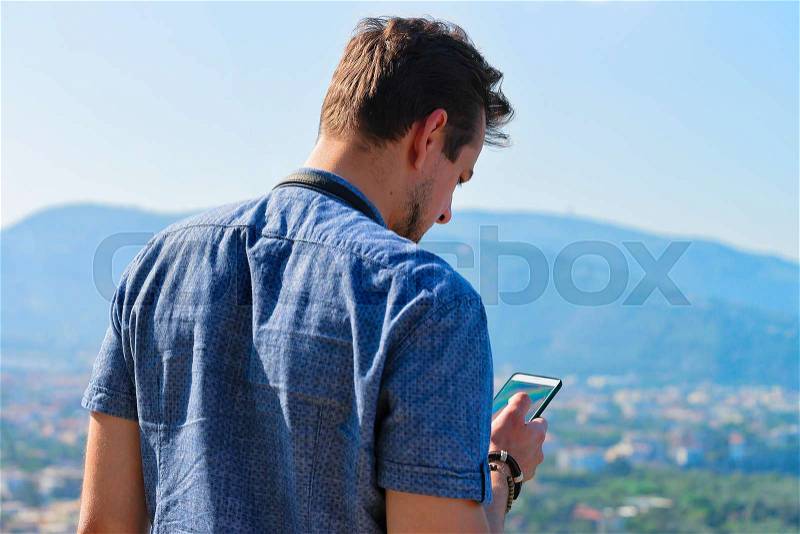 Man looking at mobile phone in Marina Grande in Sorrento, Tyrrhenian sea, Amalfi coast, Italy, stock photo
