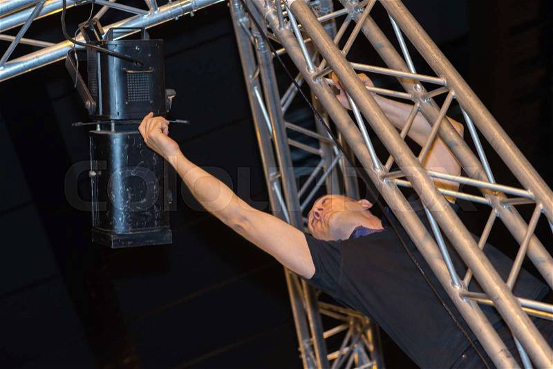 Professional stage lighting control technician at work, stock photo