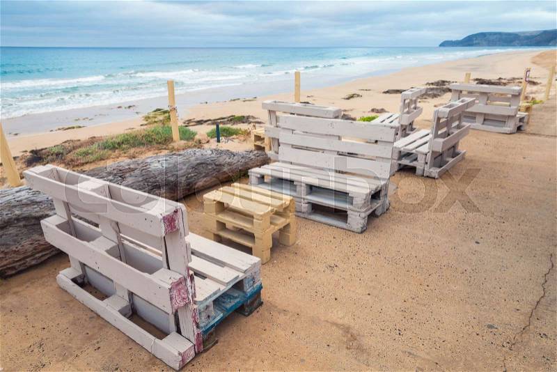 Standard white furniture made of wooden cargo pallets, cheap seaside terrace. Porto Santo island, Madeira archipelago, Portugal, stock photo