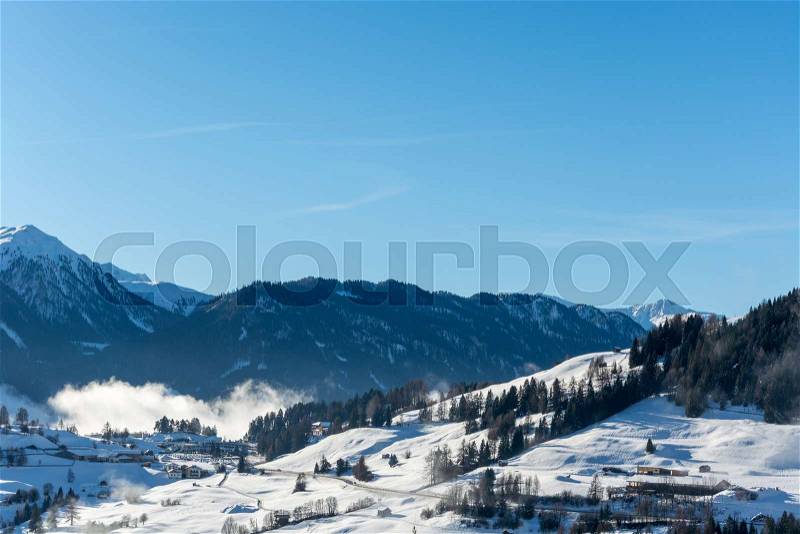 Street to Serfaus from Fiss in Austria with snowy mountains and blue sky, stock photo