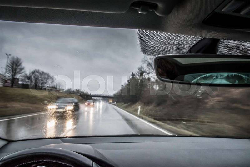 View from a moving car with traffic in rain and storm in Germany, stock photo
