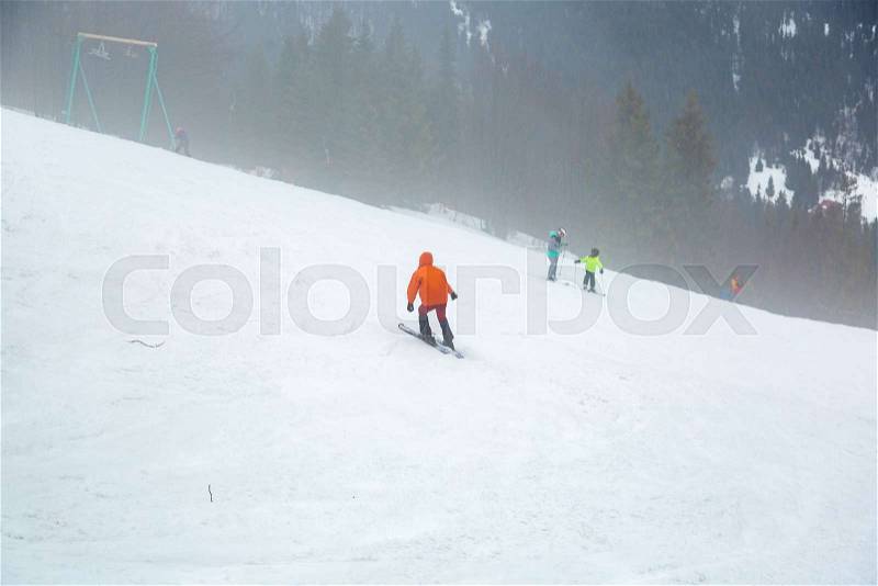 People are trained to ski on the slope near the forest and the ski lifter, stock photo