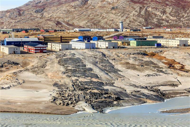 Living blocks on the hill above muddy melted glacier river with airport in the background, Kangerlussuaq settlement, Greenland, stock photo
