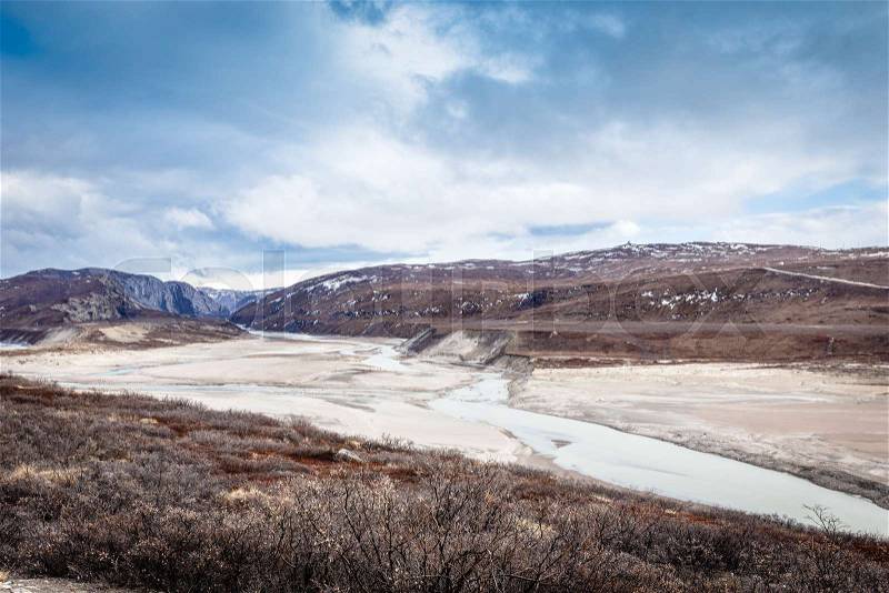 Greenlandic wastelands landscape with river and mountains in the background, Kangerlussuaq, Greenland, stock photo