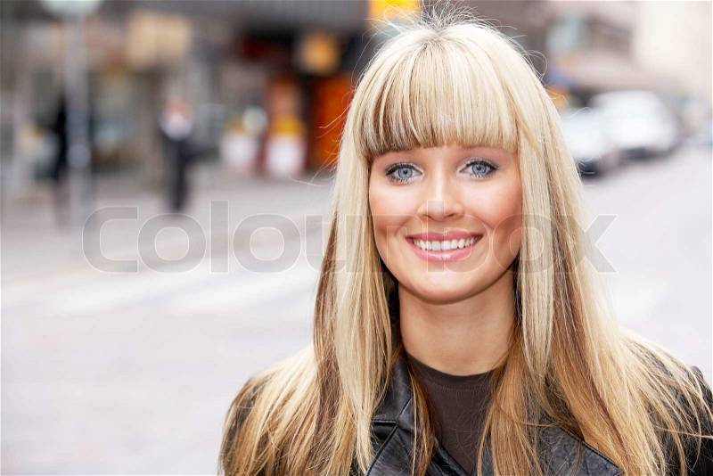 Young woman in street, looking at camera, portrait, stock photo