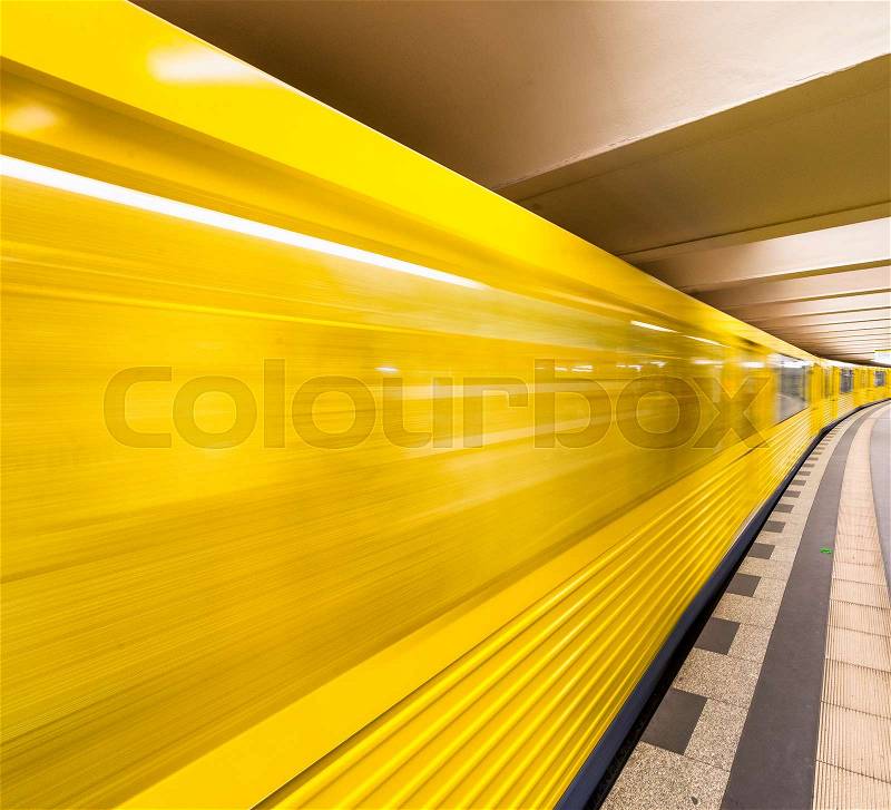 Yellow subway train speeding up on a city station. Business and transportation concept, stock photo