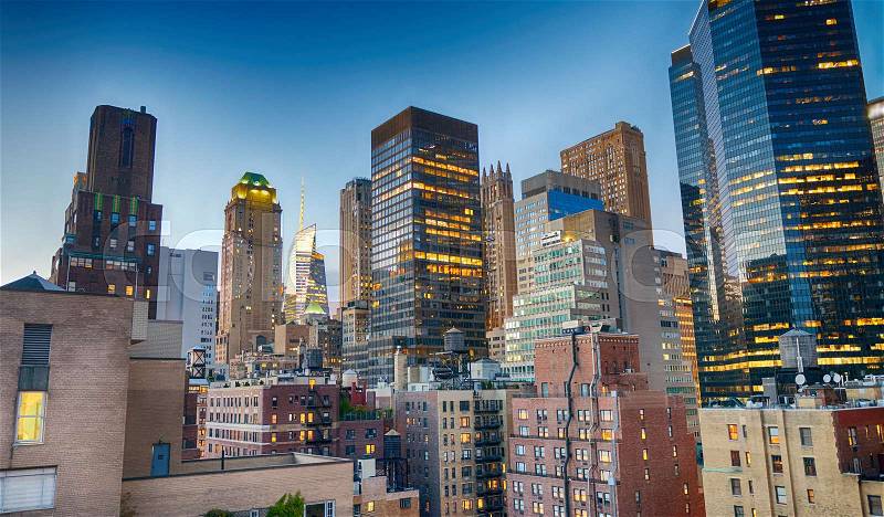 Midtown Manhattan skyscrapers as seen from city rooftop at sunset, stock photo