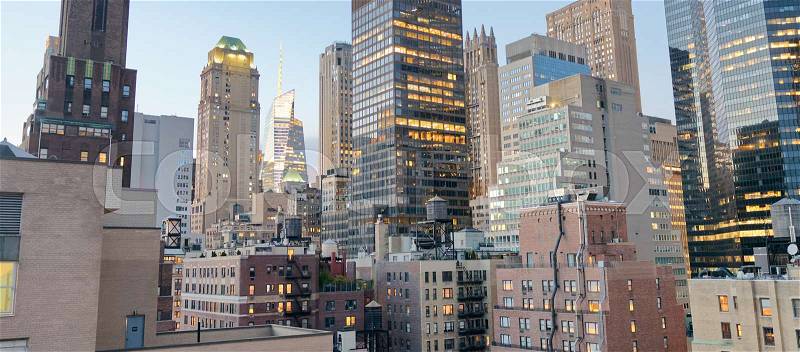 Midtown Manhattan skyscrapers as seen from city rooftop at sunset, stock photo