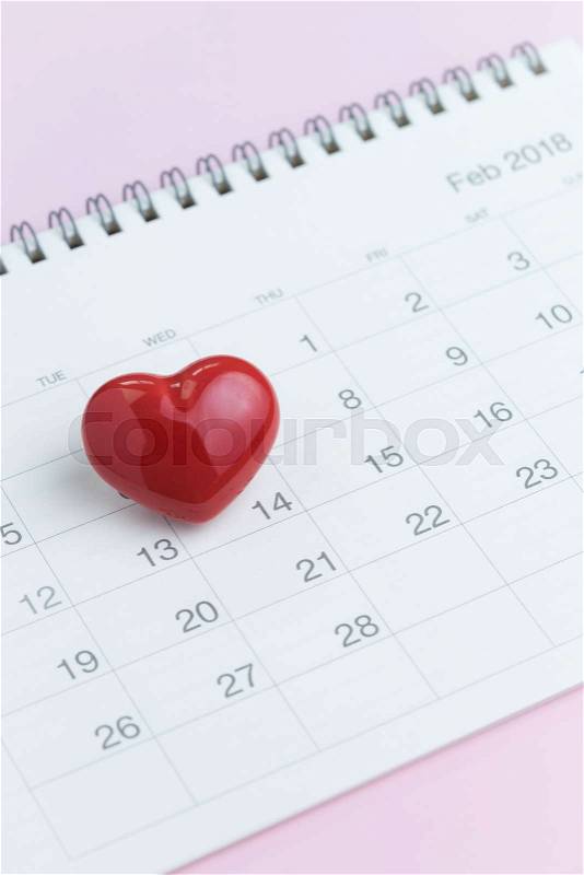Romantic Valentines day concept as clean calendar with cute red heart shape on 14th February on pink background, stock photo