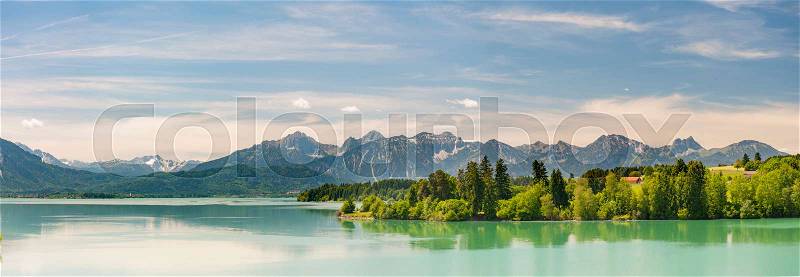 Wide panorama landscape at lake Forggensee nearby bavarian alp mountains, stock photo