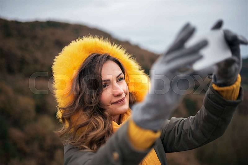Young woman using mobile at the forest. Mobile concept, stock photo