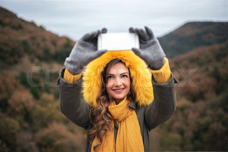 Young woman using mobile at the forest. Mobile concept, stock photo