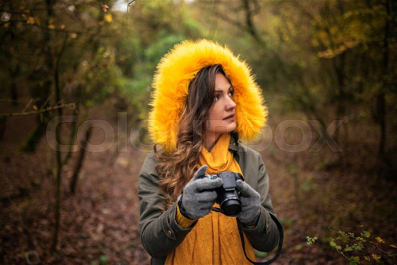 Young woman using a camera to take photo at the forest, stock photo