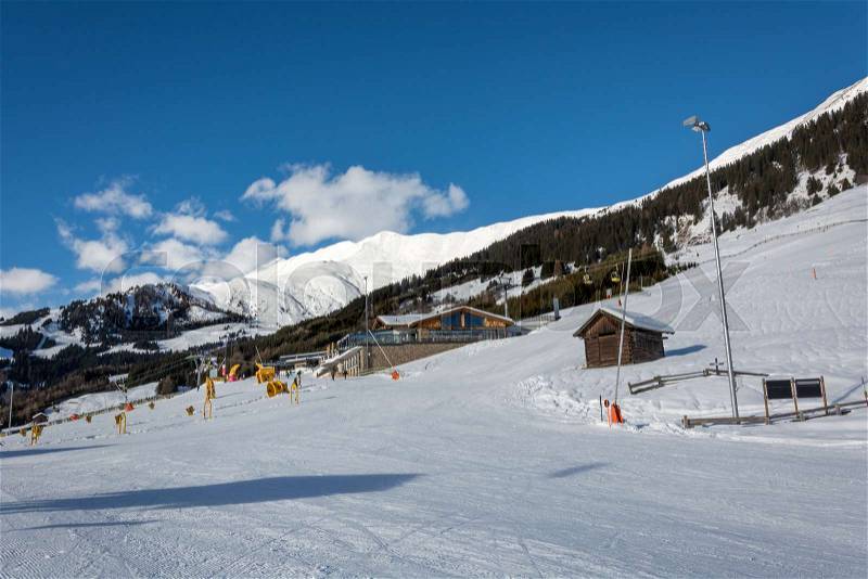 A slope and yellow gondolas with chalet in ski resort Serfaus Fiss Ladis in Austria with snowy mountains, stock photo