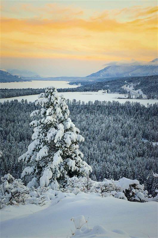 Winter Sunset of the frozen Columbia Lake with the Purcell Mountains, Fairmont Hot Springs, British Columbia, Canada, stock photo