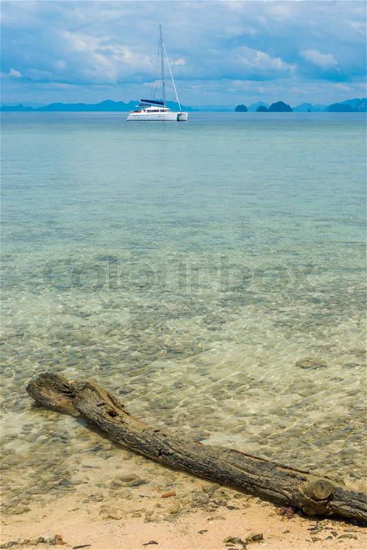 Focus on a log in the sea vertical landscape - sea, yacht and mountains on the horizon, stock photo