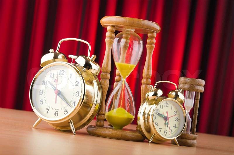 Alarm clocks and hourglass in time concept, stock photo