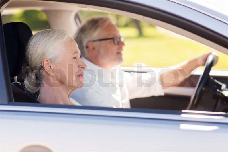 Road trip, travel and old people concept - happy senior couple driving in car, stock photo