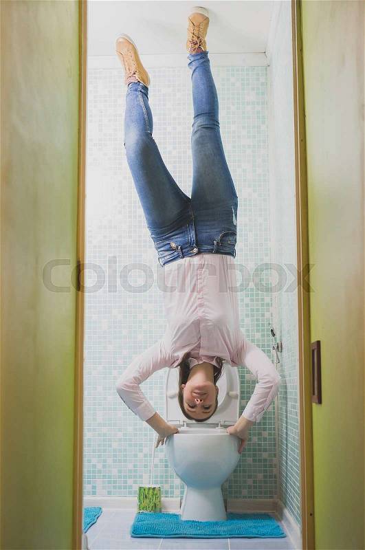Upside down House. Woman in the toilet, stock photo