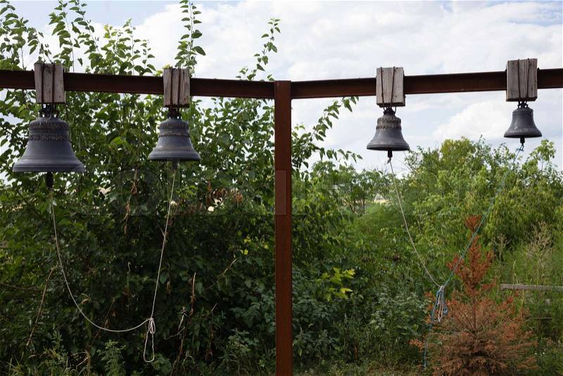 Four church bells. Church bells are on a metal cross-beam, stock photo