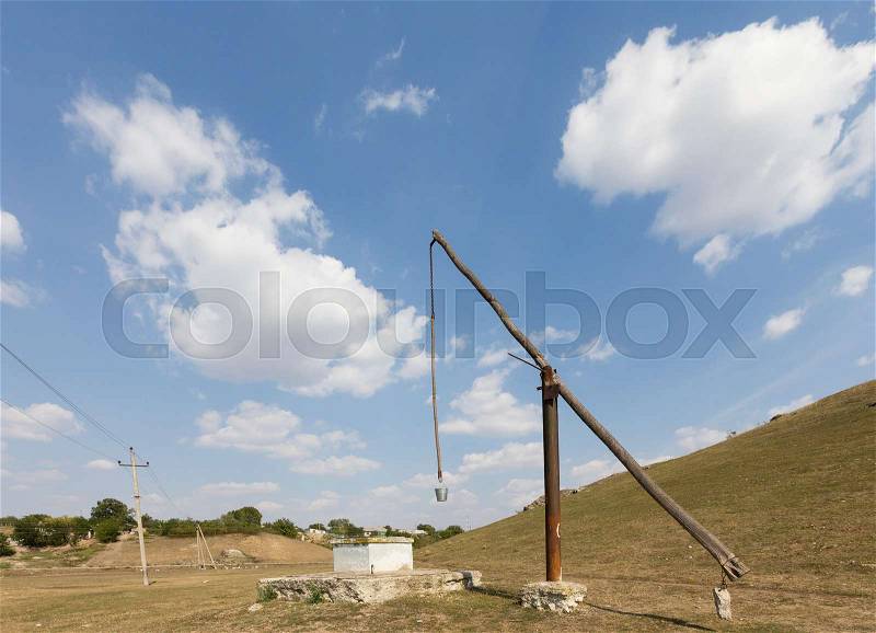 Beautiful country landscape. Old well in country next to power line, stock photo