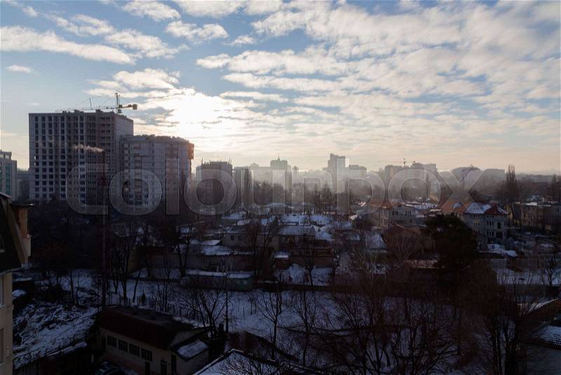 Winter in the city. Snow on roofs and the blue sky with clouds, stock photo