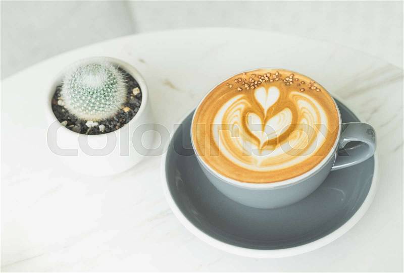 Cappuccino coffee with tree latte art in blue coffee cup on white marble table in perspective view in cafe,modern lifestyle leisure, stock photo