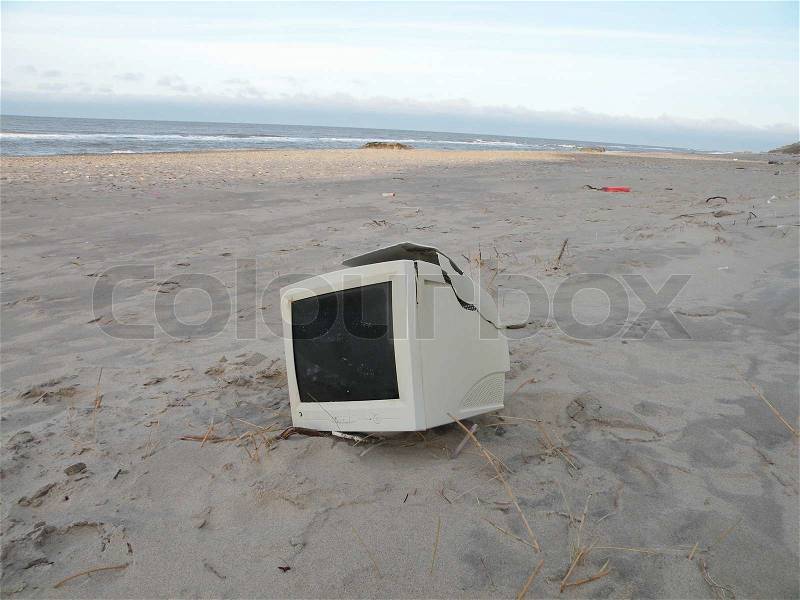 Old monitor on beach, sand, shore,, stock photo