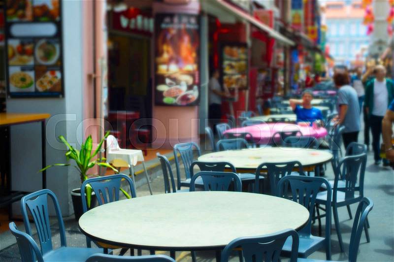 Street restaurant in Chinatown of Singapore. Focus on a table in the foreground, stock photo