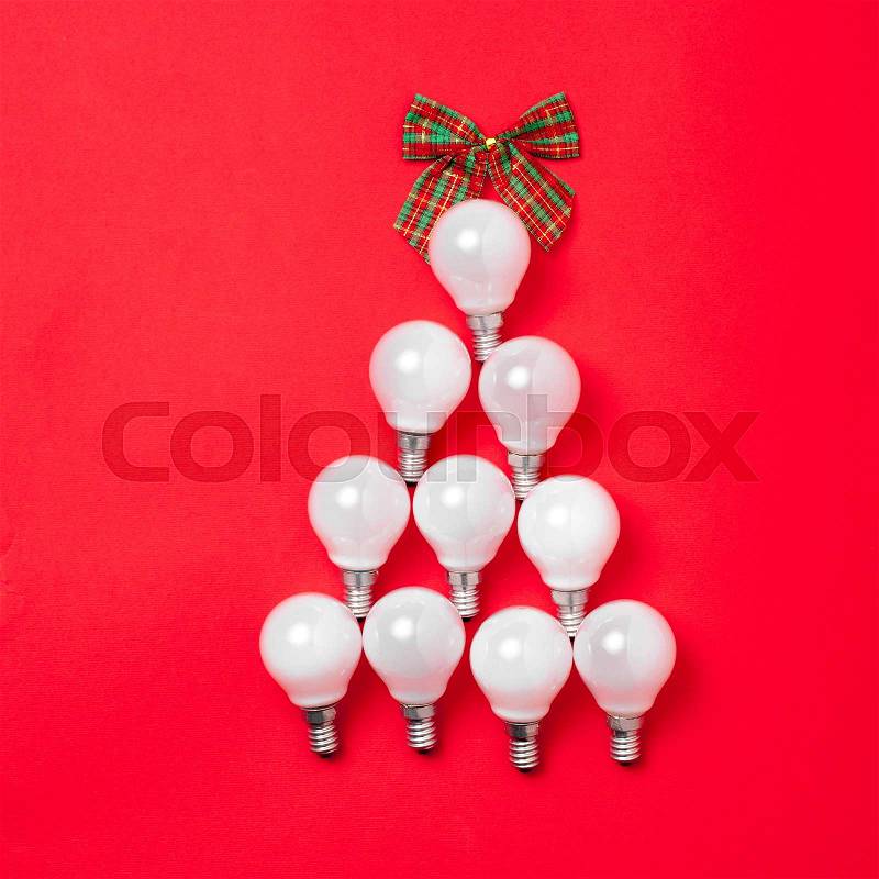 The christmas tree from lantern lamps laying on red background with copy space. Christmas ceativity decorations, stock photo