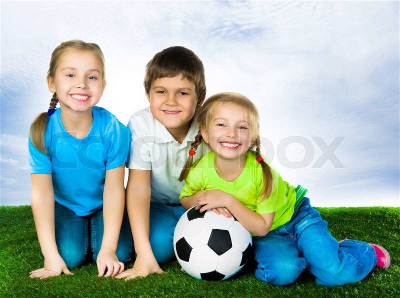 Image of happy friends on the grass with ball looking at camera, stock photo