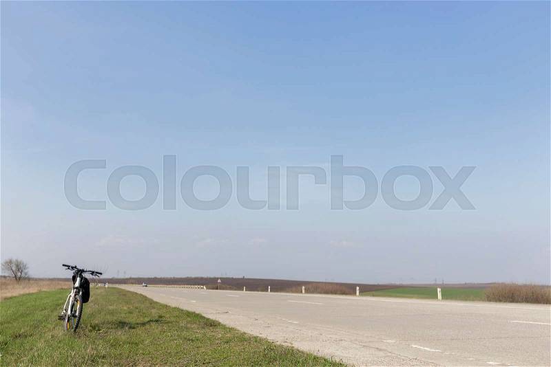 Landscape with bike. A lonely bike in the road and the blue sky, stock photo