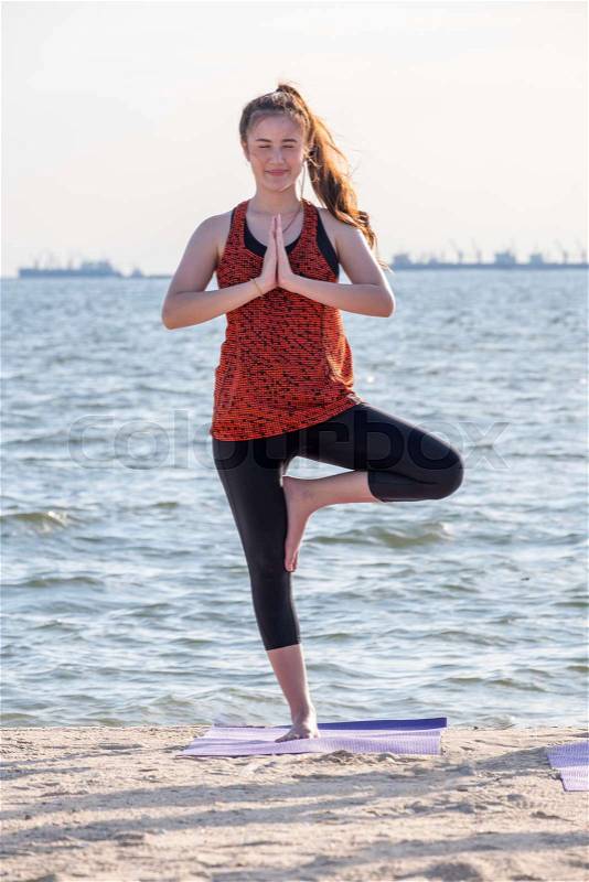 Asia woman doing tree pose and namaste with calm relax emotion at beach,Meditation pose,Wellness and Healthy Lifestyle, stock photo