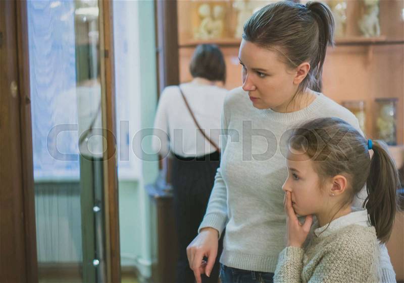 Woman and her daughter exploring expositions in museum, stock photo